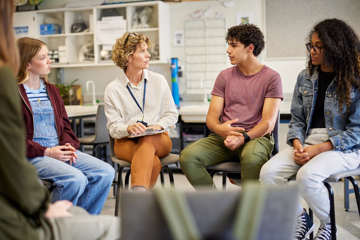 Young KC mentors surrounding youth in an open group conversation